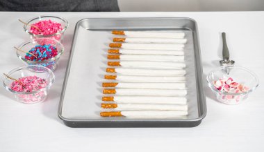 Çikolata soslu çubuk krakerlerin üzerine erimiş çikolata serpiştirmek ve Sevgililer Günü 'nde çikolata kaplı çubuk çubuklar yapmak için çikolata serpiştirmek..