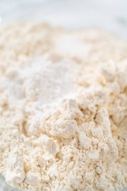 Kuru malzemelerle büyük bir bardakta çırpma kabını karıştırıp mini vanilyalı kekleri ombre pembe tereyağlı kremayla karıştırıyorum..