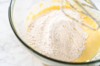 Mini vanilyalı kekler ve ombre pembe kremalı krema pişirmek için büyük bir karıştırma kabında malzemeler karıştırılıyor..