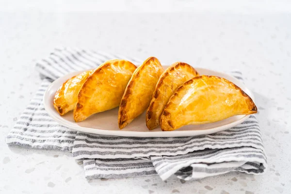 stock image Freshly baked breakfast empanadas with eggs and sweet potato on the kitchen counter.