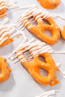 Çikolata soslu krakerlerin üzerine erimiş çikolata serpiştirmek..