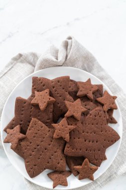 Beyaz tabakta taze pişmiş yıldız şeklinde çikolatalı kraker..