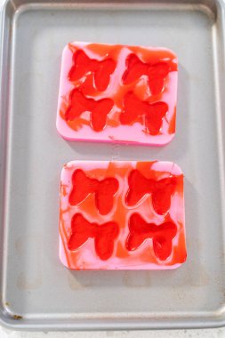 Removing chocolate bows from the silicone molds to make a chocolate pretzel Christmas wreath.