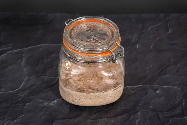Homemade wheat sourdough starter in a glass mason jar.