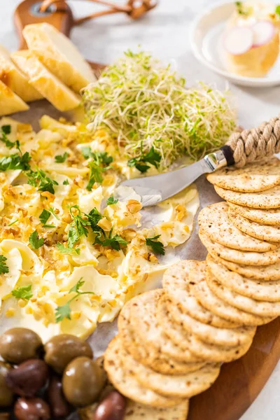 stock image Butter board with vegetables and bread on a round wood cutting board.