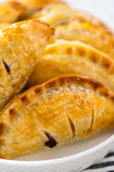 焼き立ての甘いエンパナーダとブルーベリーがキッチンカウンターに — ストック写真