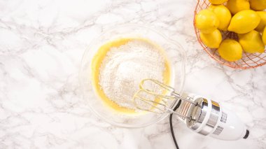 Düz yatıyordu. Adım adım. Limonlu kek hazırlamak için karıştırma kabındaki malzemeleri karıştırıyorum..