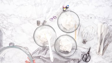 Adım adım. Düz yatıyordu. Tek boynuzlu at kurabiyesi pişirmek için besin boyasını kremaya karıştırıyorum..