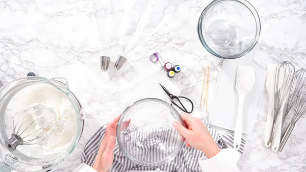 stock image Step by step. Flat lay. Mixing food coloring into the meringue to bake unicorn meringue cookies.