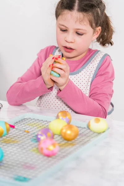 Easter egg coloring. Painting Easter eggs with gold luster.