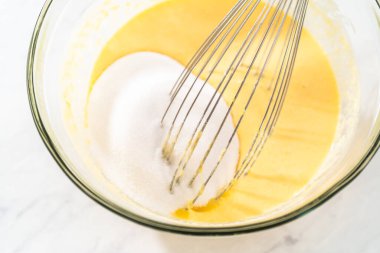 Limonlu yaban mersinli kek pişirmek için büyük bir bardakta ıslak malzemeler karıştırıyorum..