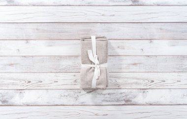 Düz yatıyordu. Beyaz ahşap bir masada yeni bir peçete yığını..