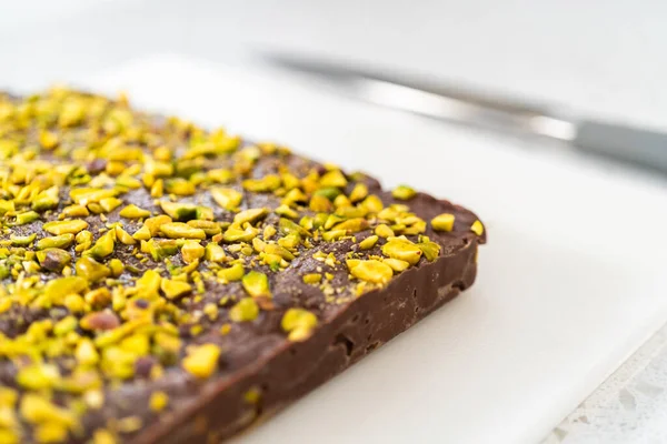 Scoring chocolate pistachio fudge into perfect squares for cutting.