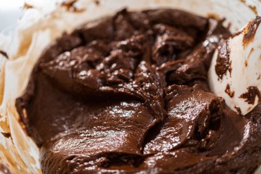 Melting white chocolate chips and other ingredients in the double boiler to prepare chocolate pistachio fudge.