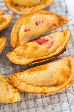 Mutfak tezgahındaki tavada taze pişmiş vişneli börek var..