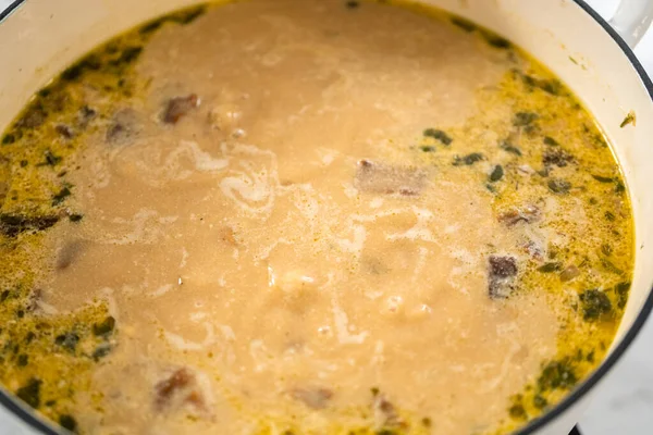 stock image Cooking creamy wild mushroom soup made in an enameled dutch oven.