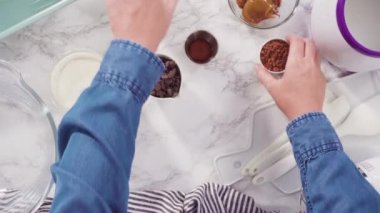 Time lapse. Flat lay. Step by step. Melting chocolate chips to prepare homemade chocolate ice cream.