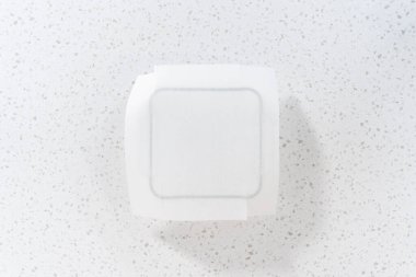 Flat lay. Lining glass baking pan with parchment paper sheet to prepare white chocolate cranberry pecan fudge.