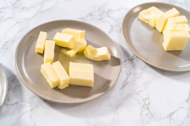 Tezgahın üzerinde yumuşatılmış tuzsuz tereyağı çubukları..