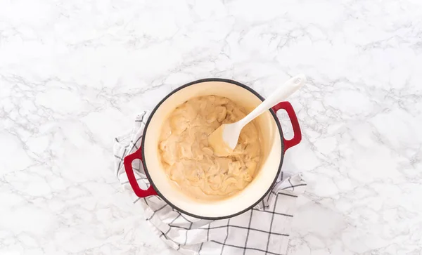 stock image Flat lay. Mixing ingredients in an enameled dutch oven to prepare chicken alfredo pasta.