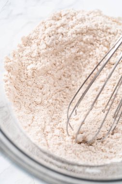 Yumuşak yulaf ezmesi üzümlü cevizli kurabiye pişirmek için büyük bir bardakta kuru malzemeler karıştırıyorum..