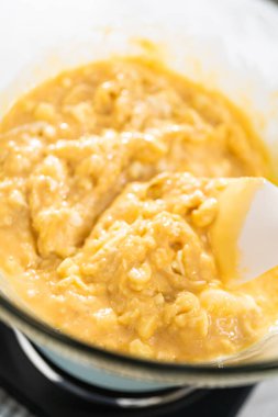 Eriyen beyaz çikolata parçacıkları ve diğer malzemeler kaynamış suyun üzerinde karışıp kızılcık fıstıklı şekerleme hazırlıyor..