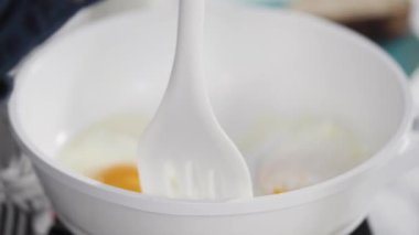 Manzarayı kapat. Beyaz tavada taze yumurta kızartıyorlar..