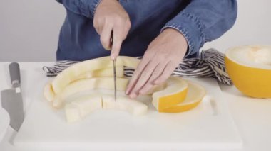 Adım adım. Beyaz kesme tahtasında kaygan altın çiğ taneli kavun.