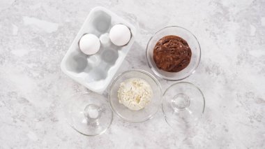 Düz yatıyordu. Adım adım. Çikolatalı kek hazırlamak için cam karıştırma kaselerinde bulunan malzemeler..