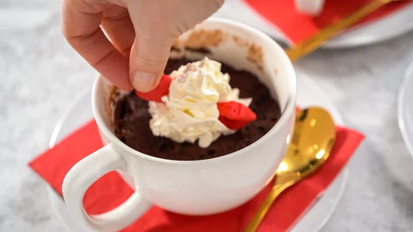 Step by step. Chocolate mug cakes garnished with whipped cream and chocolate hearts and lips.