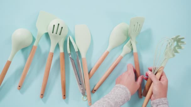 Flach Lag Neue Blaue Silikon Küchenutensilien Mit Holzgriffen Auf Blauem — Stockvideo