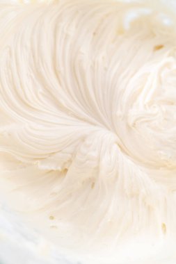 Krem peynirli krema hazırlamak için büyük bir bardakta karıştırma malzemeleri..