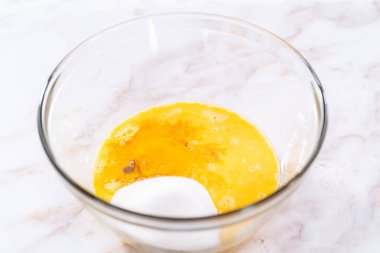 Elmalı Sharlotka keki pişirmek için karışımı büyük bir bardakta karıştırıyorum..