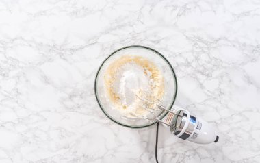 Düz yatıyordu. Krem peynirli krema hazırlamak için büyük bir bardakta karıştırma malzemeleri..