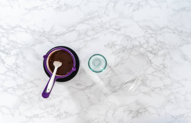 Düz yatıyordu. Çikolata parçalarını eritip, eritip, pandaya benzeyen kurabiyeler yapmak için çikolata kreması yapmak..