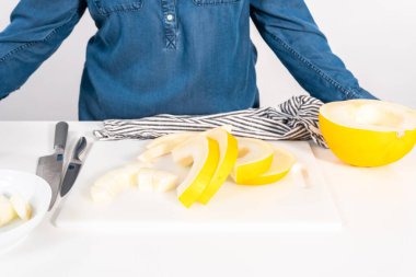 Beyaz kesme tahtasında kaygan altın çiğ taneli kavun.