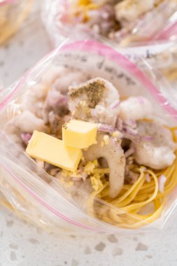 Ev yapımı donmuş karides paketleri plastik yeniden mühürlenebilir poşetlere hazırlanıyor..