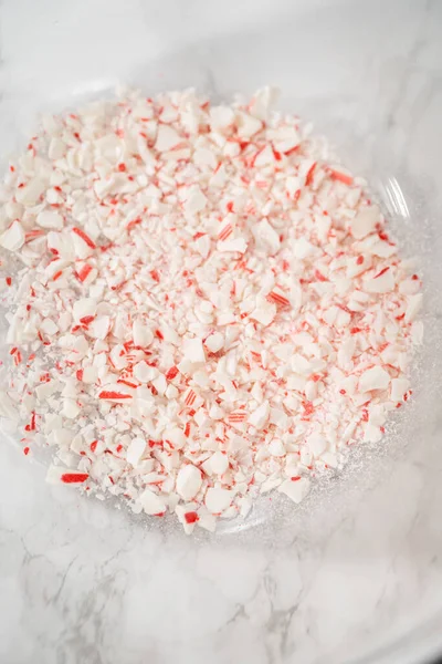 stock image Sifting crushed peppermint candies through the spider strainer into the glass mixing bowls.