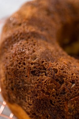 Soğutucu rafı yuvarlamak için taze fırınlanmış havuçlu keki kek kalıbından kaldırıyorum..