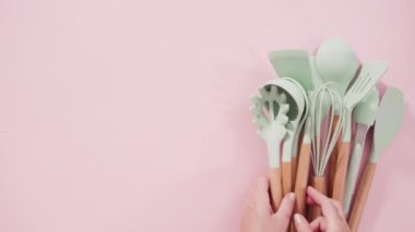 Düz yatıyordu. Pembe arka planda ahşap saplı yeni mavi silikon mutfak aletleri..