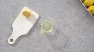 Düz yatıyordu. Adım adım. Limonlu kek pişirmek için taze limon sıkmak..