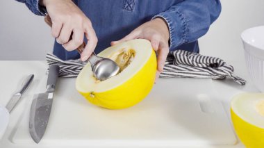 Adım adım. Beyaz kesme tahtasında kaygan altın çiğ taneli kavun.