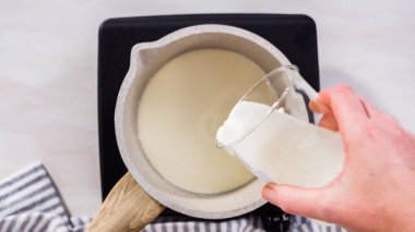 Adım adım. Düz yatıyordu. Elektrikli bir tavanın üzerinde küçük bir tencereyle çikolata kreması hazırlıyorum..