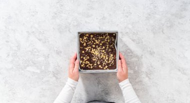 Düz yatıyordu. Çikolatalı fındıklı şekerlemeyi parşömenle kaplı kare bir cheesecake tavasından kaldırıyorum..