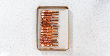 Düz yatıyordu. Çubuk krakerleri erimiş çikolataya batırıp Cadılar Bayramı 'nda çikolata kaplı çubuk kraker yapmak..