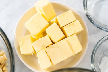 Beyaz çikolatalı macadamia fındığı hazırlamak için cam karıştırma kabında ölçülmüş malzemeler..