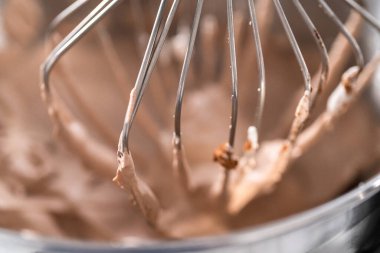 Ev yapımı çikolatalı dondurma yapmak için mutfak mikserinin malzemelerini karıştırıyorum..