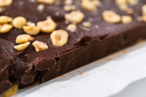 Removing Chocolate Hazelnut Fudge Square Cheesecake Pan Lined Parchment — Stock Photo, Image