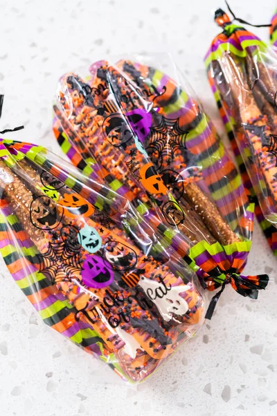 stock image Packaging Halloween chocolate-covered pretzel rods with sprinkles into gift bags.