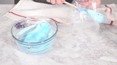 Time lapse. Step by step. Transfering meringue mix into piping bags with metal tips to bake unicorn meringue pops cookies.